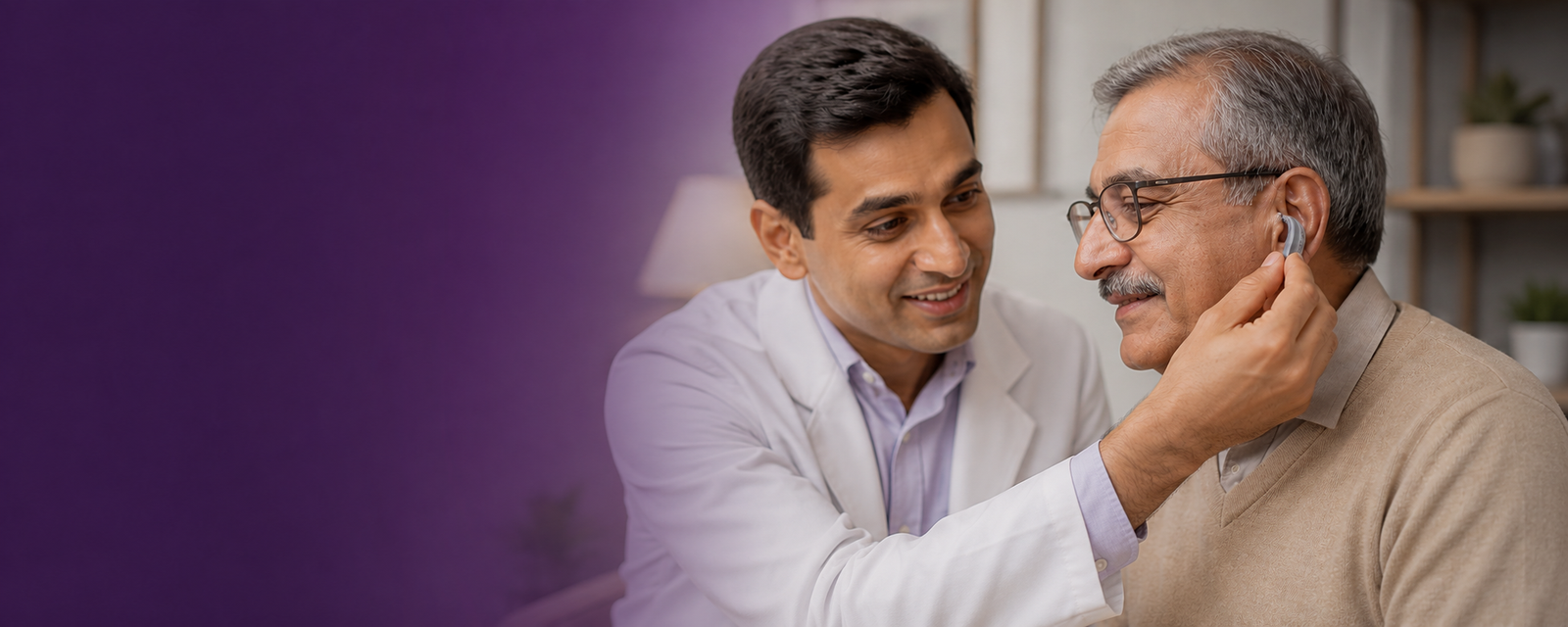 A hearing specialist fitting a behind-the-ear hearing aid on an Indian senior man